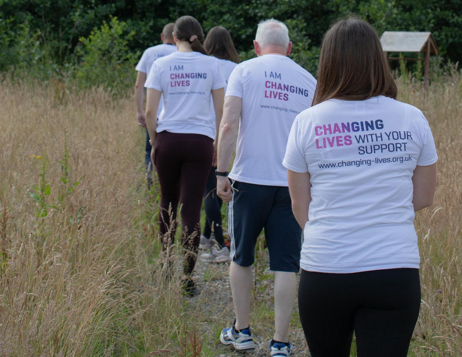 A group of people fundraising for Changing Lives wearing Changing Lives with your support t-shirts.